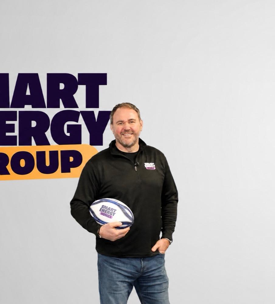 A member of the Smart Energy Group team in front of the Smart Energy Group logo